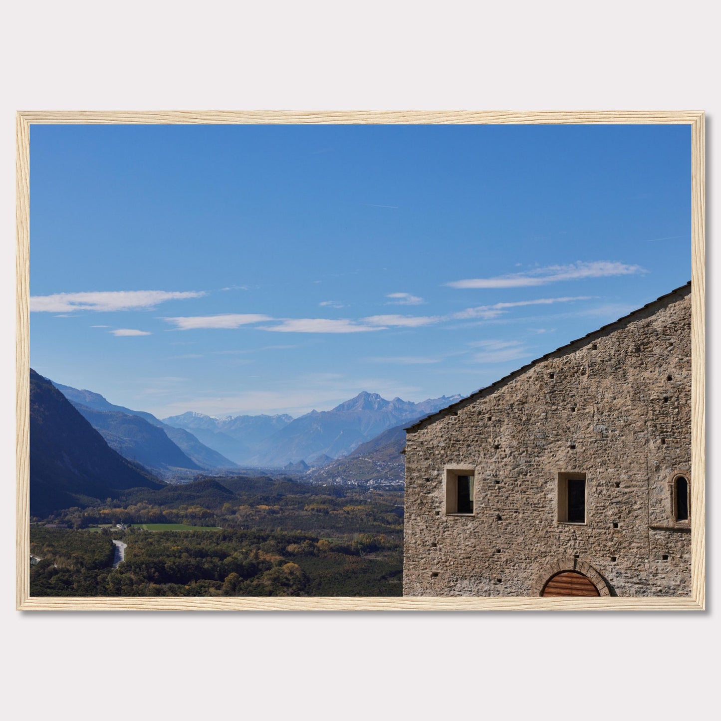 This stunning photograph captures a serene landscape with a historic stone building in the foreground and majestic mountains in the background.