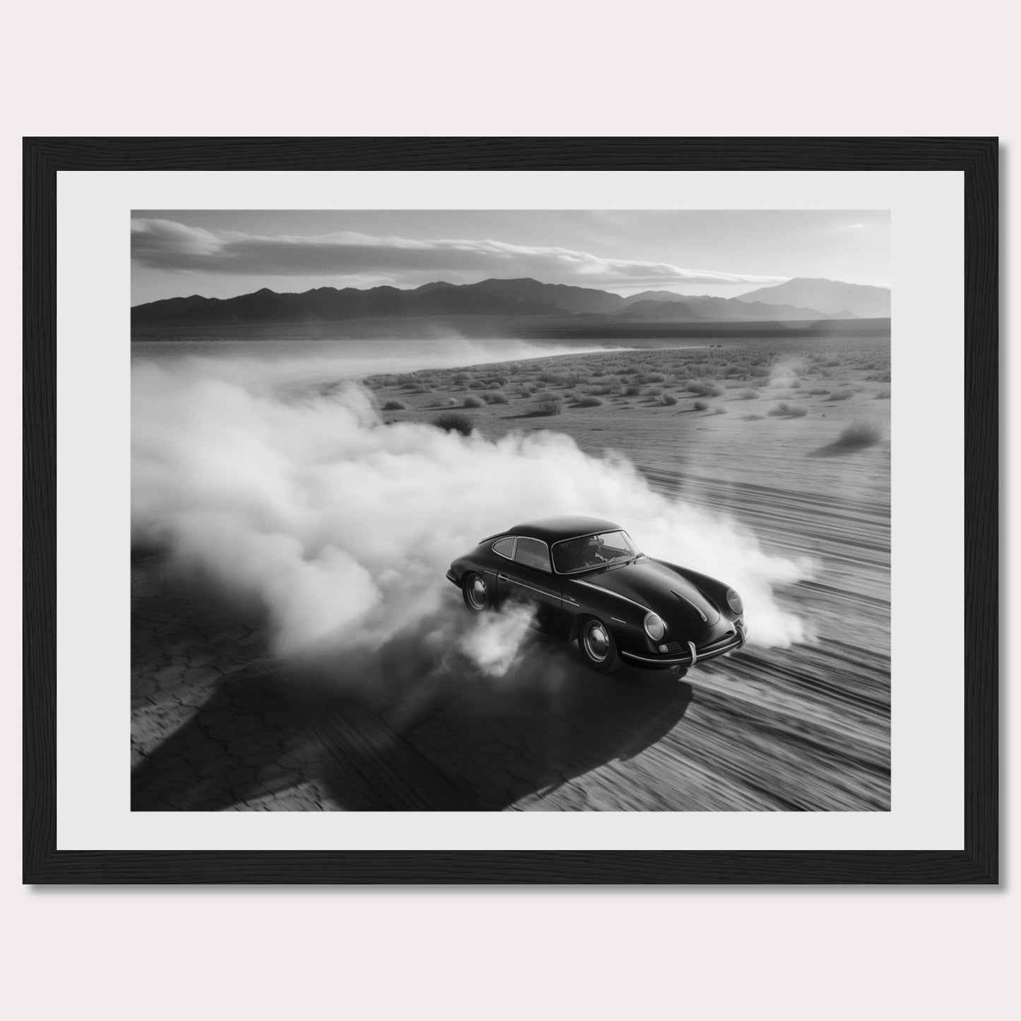 This striking black and white photograph captures a classic car speeding through a desert landscape, leaving a trail of dust in its wake. The image exudes a sense of freedom and adventure, with the distant mountains adding to the dramatic scenery.