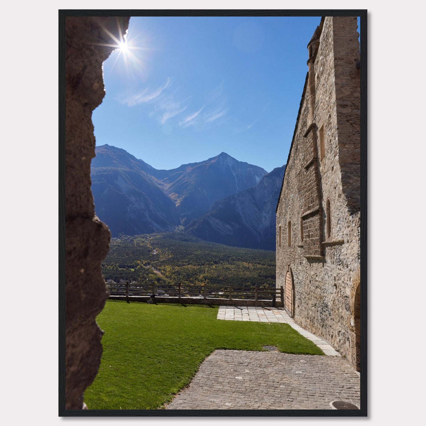 This captivating image showcases a stunning view of a mountainous landscape framed by the rustic stone walls of an ancient structure. The bright sun shines above, casting a warm glow over the scene.