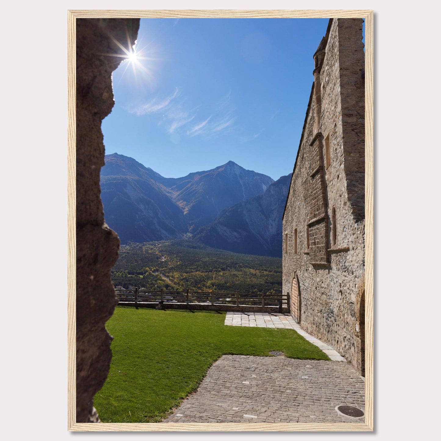 This captivating image showcases a stunning view of a mountainous landscape framed by the rustic stone walls of an ancient structure. The bright sun shines above, casting a warm glow over the scene.