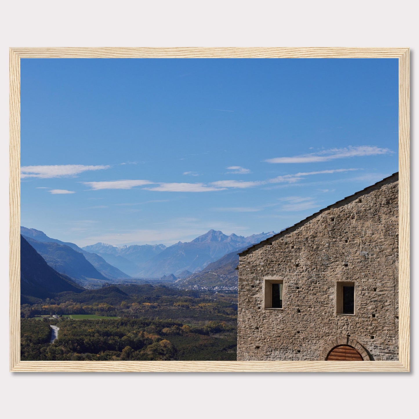 This stunning photograph captures a serene landscape with a historic stone building in the foreground and majestic mountains in the background.