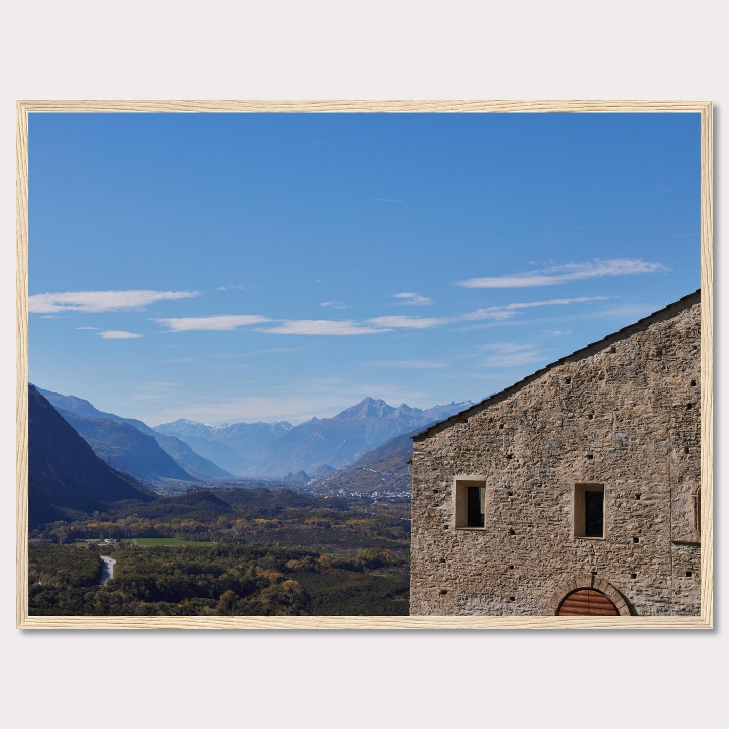 This stunning photograph captures a serene landscape with a historic stone building in the foreground and majestic mountains in the background.