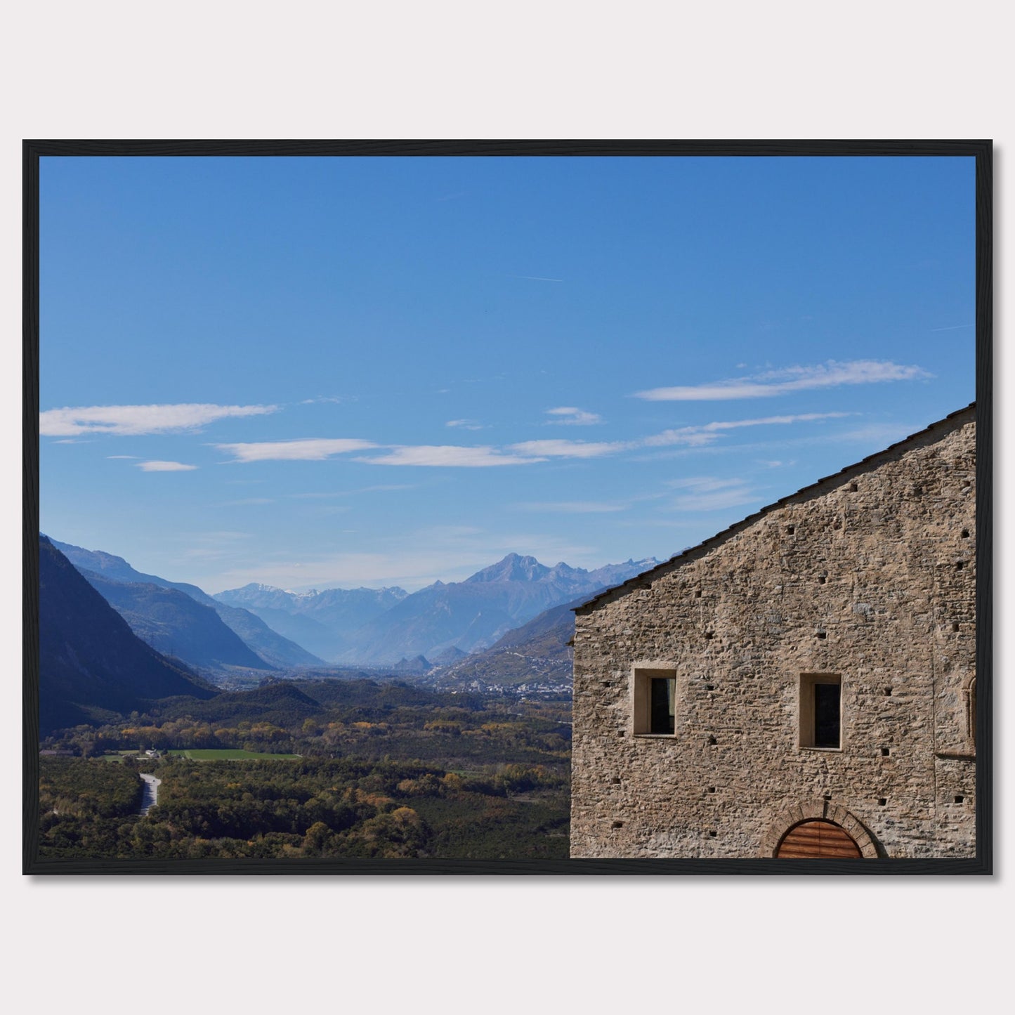 This stunning photograph captures a serene landscape with a historic stone building in the foreground and majestic mountains in the background.