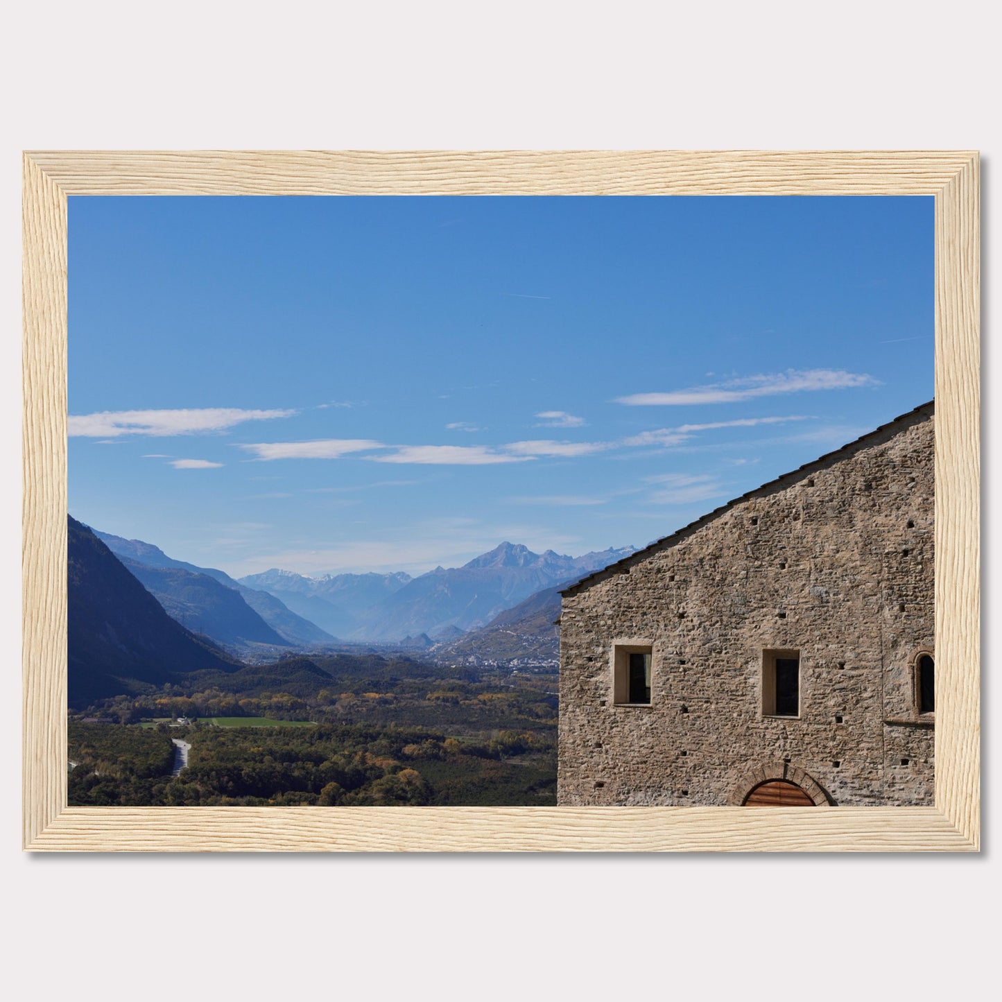 This stunning photograph captures a serene landscape with a historic stone building in the foreground and majestic mountains in the background.