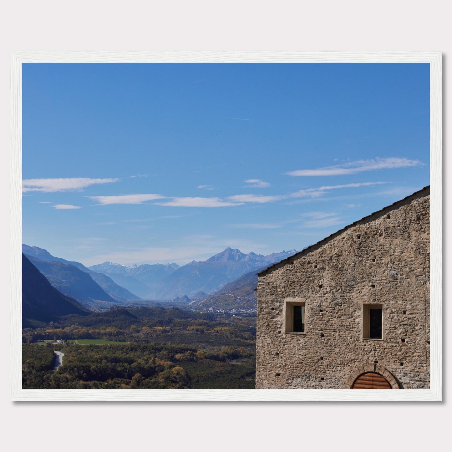 This stunning photograph captures a serene landscape with a historic stone building in the foreground and majestic mountains in the background.