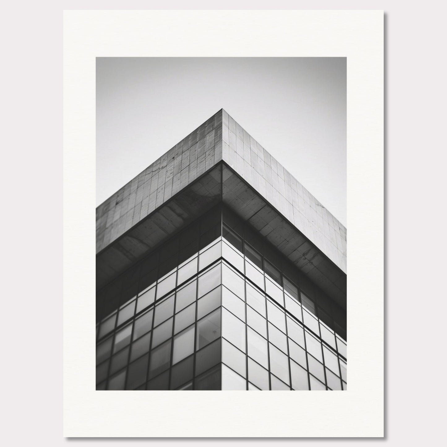 This striking black and white photograph captures the sharp, geometric lines of a modern architectural structure. The image focuses on the corner of a building, emphasizing its sleek glass windows and concrete elements.